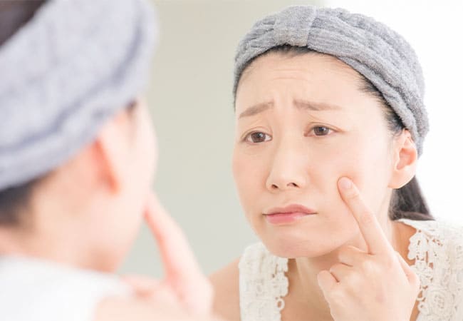 肌を指す女性